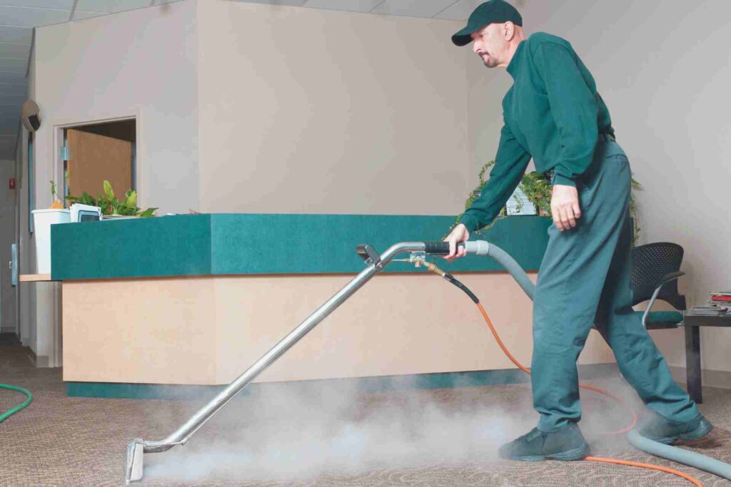 A man steam cleaning a carpet with a vacuum cleaner, effectively removing dirt and stains for a fresh appearance.