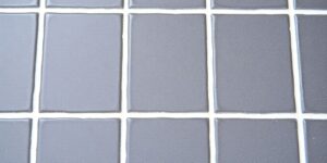 Close-up of clean white grout on dark tiles.